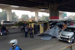 Truk Mengangkut Talang Baja Terguling di Dekat Gerbang Tol Kebon Nanas