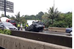 Jalanan Licin, Mobil Sedan Terguling di Tol Pondok Ranji
