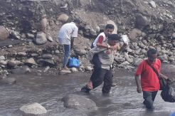Polisi Ini Gendong Warga yang Sakit Seberangi Sungai untuk Berobat