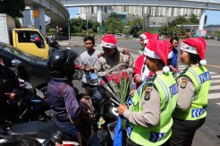 Polisi Sinterklas Bagikan Bunga di Jalanan