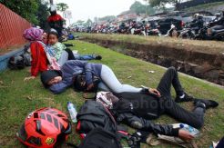 Kelelahan Berkendara, Pemudik Motor Istirahat di Tepi Jalan