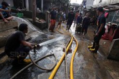 Petugas Pemadam Kebakaran Bantu Warga Bersihkan Lumpur Sisa Banjir