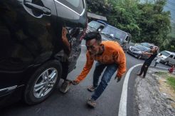Tukang Ganjal Ban Bantu Kendaraan Pemudik di Tanjakan Gentong