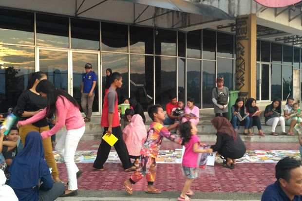 Para penggiat literasi di Lampung menggelar acara Ngabu Book Read di Menara Siger Lampung. Mereka menunggu waktu buka puasa sembari menebar virus baca. Foto/MNC Media/Heri Fulistiawan