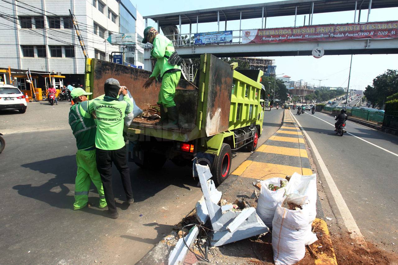 Petugas Bersihkan Puing...