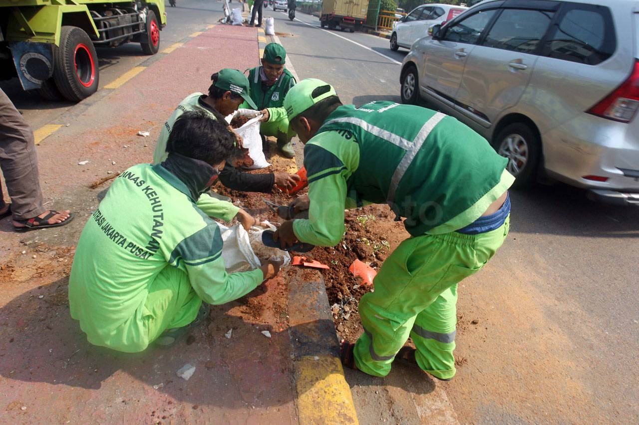 Petugas Bersihkan Puing...
